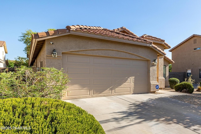 3713 W Nancy Ln, Phoenix, AZ 85041 - view of front of home with an attached garage, concrete driveway, a tiled roof, and stucco siding