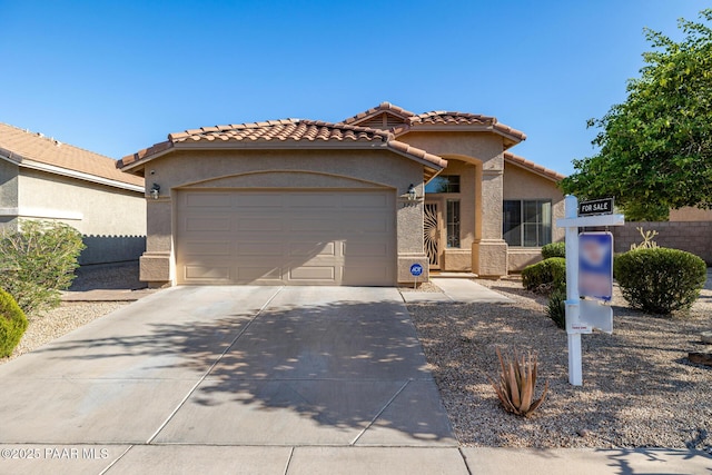3713 W Nancy Ln, Phoenix, AZ 85041 - mediterranean / spanish house with an attached garage, concrete driveway, stucco siding, and a tile roof