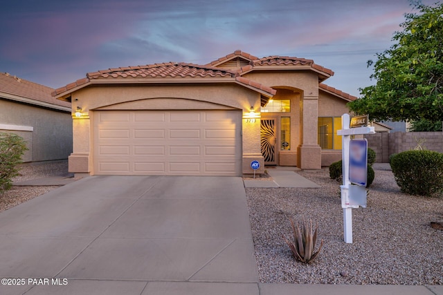 3713 W Nancy Ln, Phoenix, AZ 85041 - mediterranean / spanish-style house featuring an attached garage, driveway, stucco siding, and a tiled roof