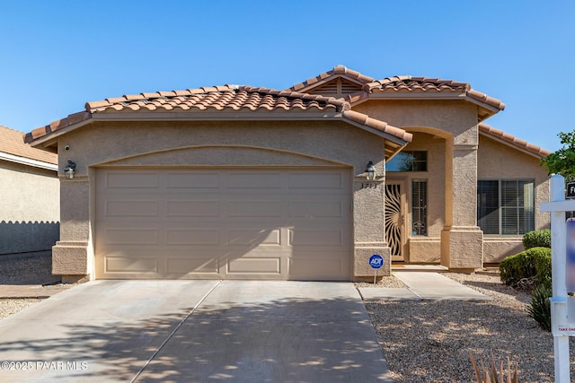3713 W Nancy Ln, Phoenix, AZ 85041 - mediterranean / spanish-style home with an attached garage, concrete driveway, a tile roof, and stucco siding