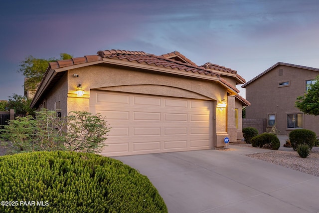 3713 W Nancy Ln, Phoenix, AZ 85041 - mediterranean / spanish home featuring a garage, concrete driveway, a tile roof, and stucco siding