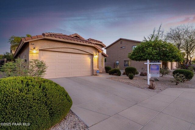 3713 W Nancy Ln, Phoenix, AZ 85041 - mediterranean / spanish-style house with concrete driveway, a garage, stucco siding, and a tile roof