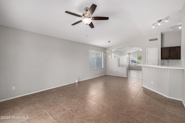 3713 W Nancy Ln, Phoenix, AZ 85041 - unfurnished living room featuring ceiling fan, vaulted ceiling, dark tile patterned flooring, and arched walkways