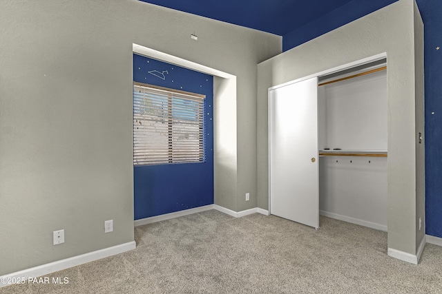 unfurnished bedroom with a closet, baseboards, and carpet floors