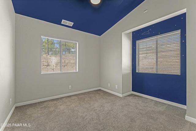 empty room with visible vents, vaulted ceiling, carpet floors, and baseboards