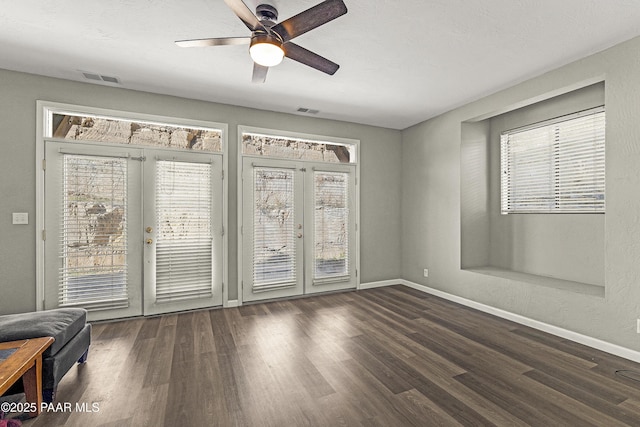 empty room with ceiling fan, plenty of natural light, and baseboards
