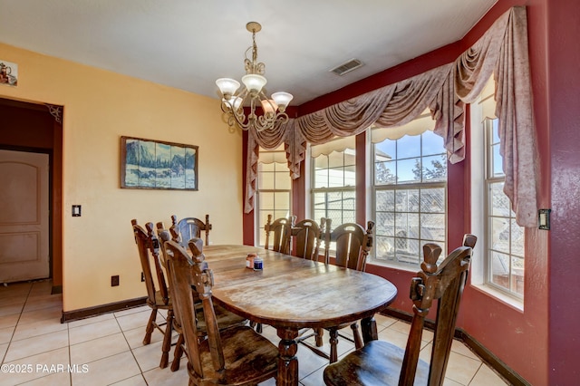 dining area with a chandelier, light tile patterned flooring, visible vents, and baseboards