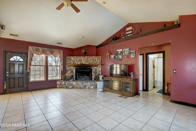 unfurnished living room with vaulted ceiling, a stone fireplace, light tile patterned flooring, and visible vents