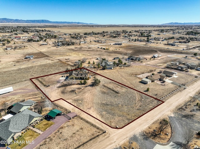 drone / aerial view featuring view of desert, a rural view, and a mountain view