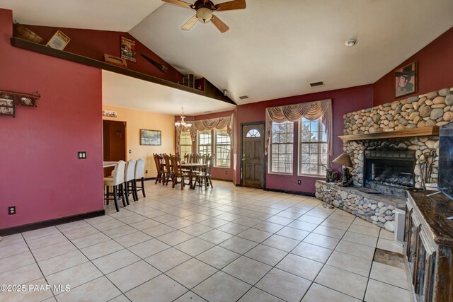 living room featuring visible vents, light tile patterned flooring, a fireplace, high vaulted ceiling, and ceiling fan with notable chandelier