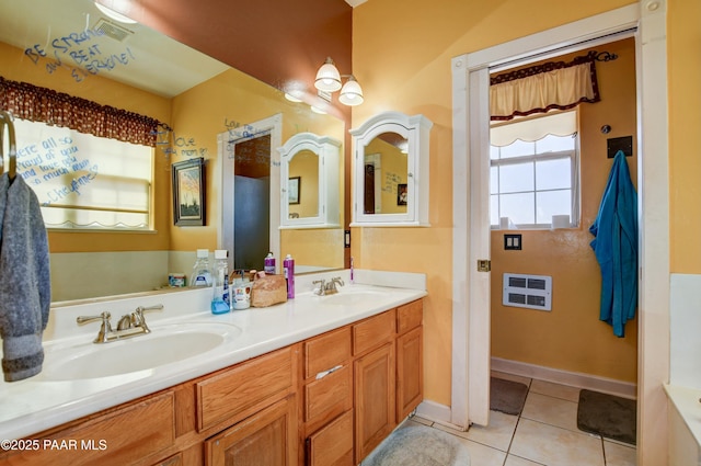 bathroom with tile patterned flooring, a sink, baseboards, and double vanity