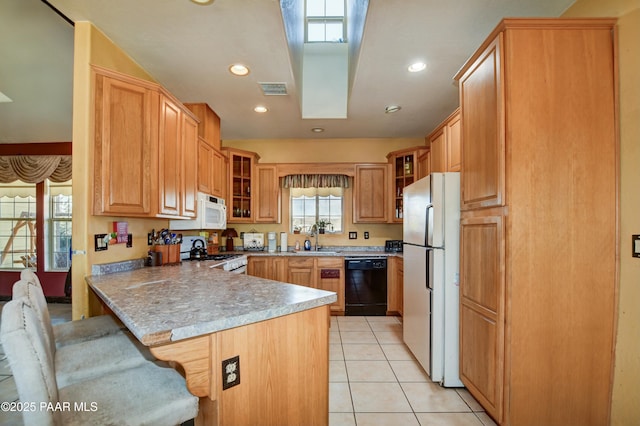 kitchen featuring a peninsula, white appliances, a sink, and glass insert cabinets