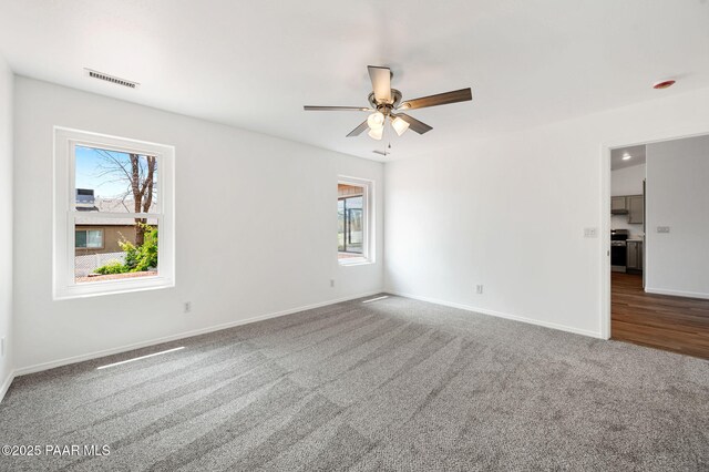 1242 N Oxbow Dr, Dewey-Humboldt, AZ 86327 - unfurnished room featuring carpet floors, plenty of natural light, a ceiling fan, and baseboards