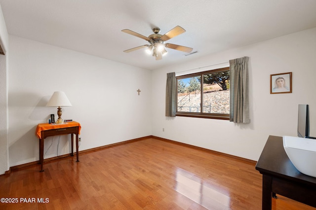 interior space with wood-type flooring and ceiling fan