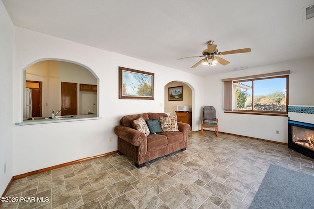 living area with sink and ceiling fan