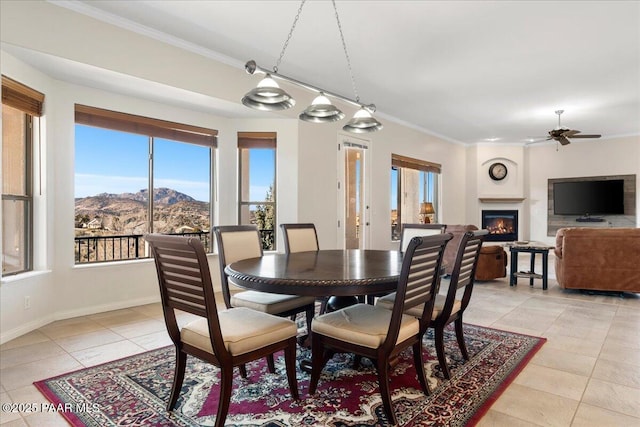 tiled dining room featuring ceiling fan, a mountain view, and ornamental molding