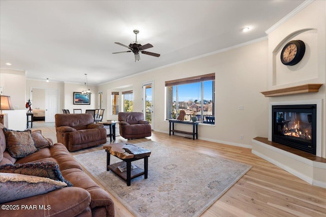 living room with ceiling fan, light wood-type flooring, and ornamental molding