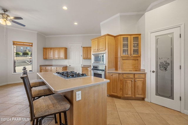 kitchen featuring a kitchen bar, crown molding, a center island, and stainless steel appliances