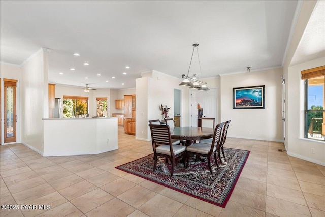 tiled dining space with ceiling fan, plenty of natural light, and crown molding