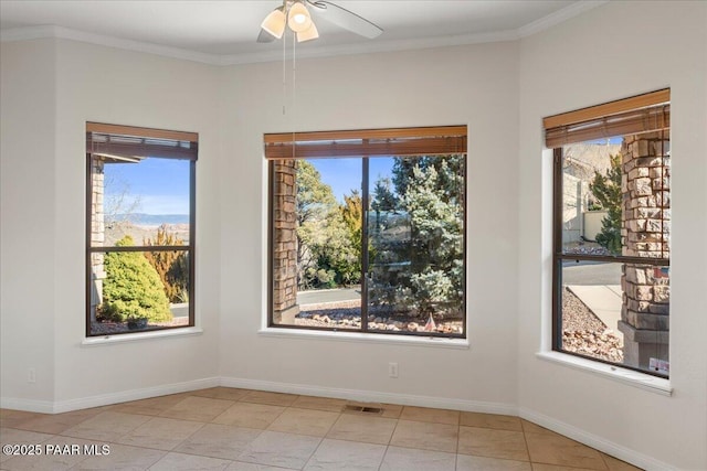 tiled empty room with ceiling fan, a wealth of natural light, and crown molding