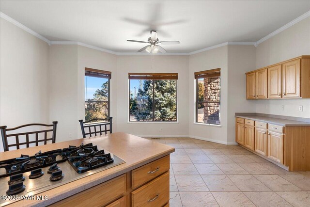 kitchen featuring ceiling fan, light brown cabinetry, stainless steel gas stovetop, and ornamental molding