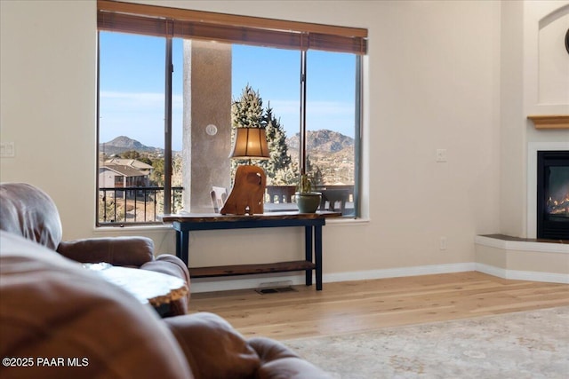 sitting room with a mountain view and hardwood / wood-style floors