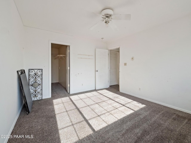 unfurnished bedroom with ceiling fan, light carpet, a closet, and a walk in closet