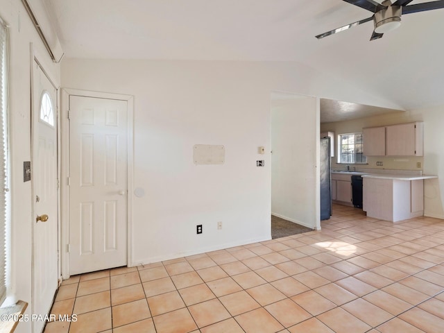 interior space featuring lofted ceiling, light tile patterned floors, and ceiling fan