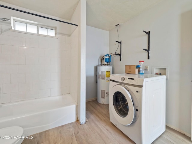 laundry room featuring electric water heater, washer / clothes dryer, and light wood-type flooring