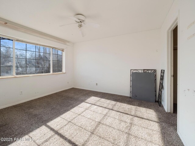 carpeted spare room featuring ceiling fan