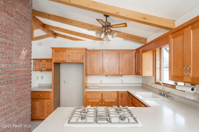 kitchen with white gas stovetop, sink, backsplash, and lofted ceiling with beams