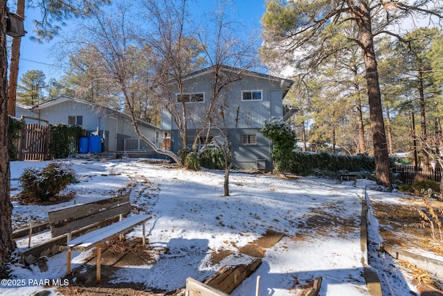 view of snow covered back of property