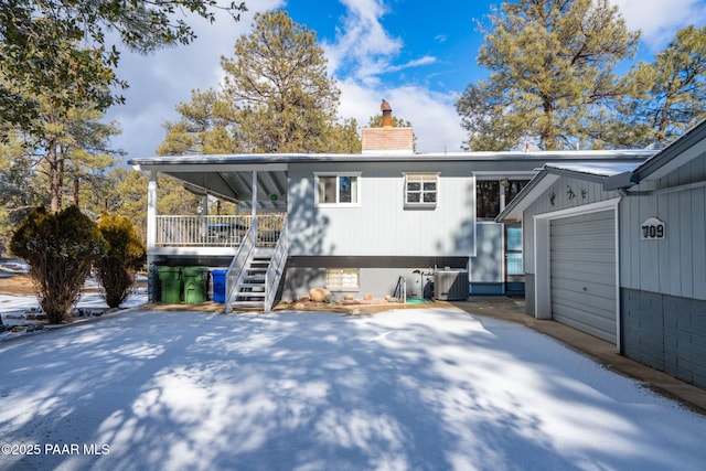 back of property with a garage and a porch