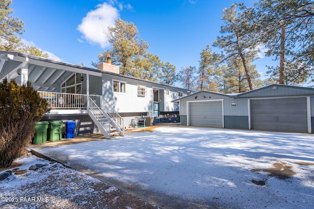 view of front of property with central AC unit, a garage, and a sunroom