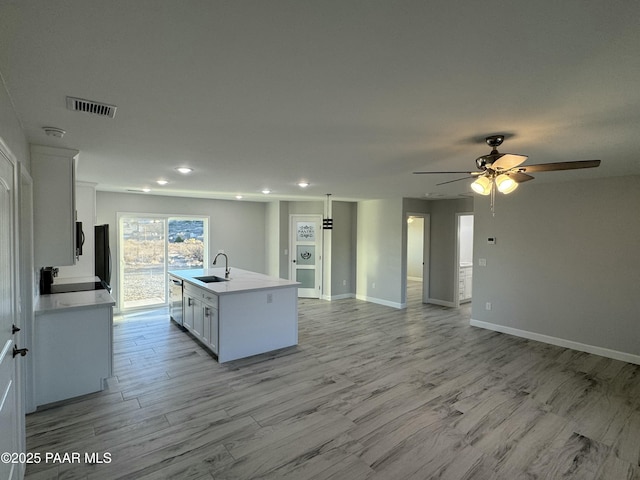 kitchen featuring a sink, visible vents, white cabinets, light countertops, and stainless steel dishwasher