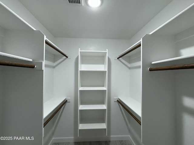 spacious closet featuring visible vents and wood finished floors