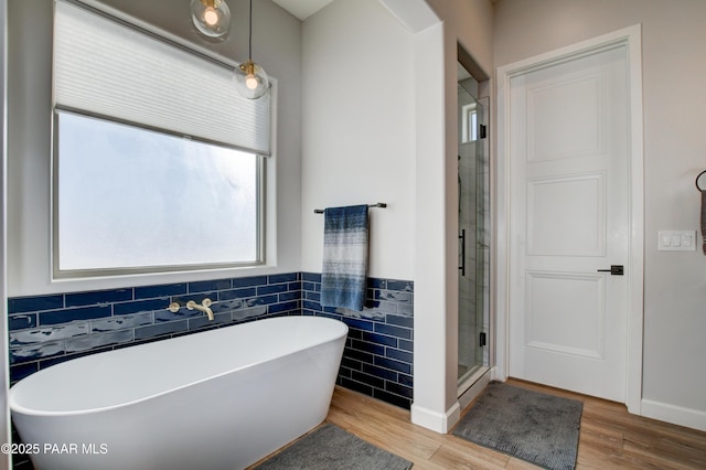 bathroom with hardwood / wood-style flooring, shower with separate bathtub, and tile walls