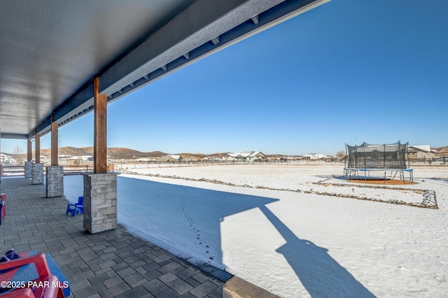 snow covered patio featuring a trampoline