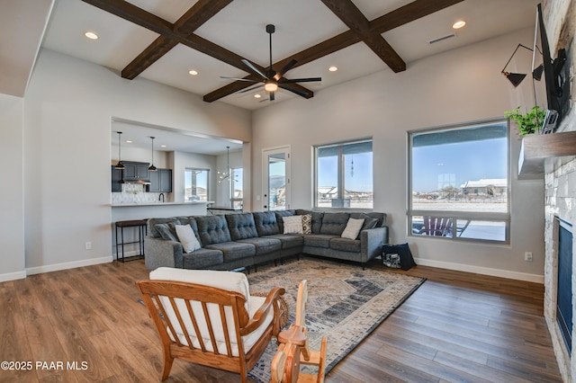 living room featuring beam ceiling, coffered ceiling, dark wood-type flooring, and a fireplace