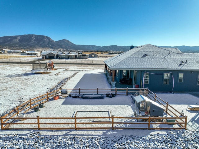 snow covered rear of property featuring a mountain view