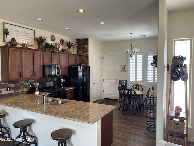 6175 Greer Ln, Prescott Valley, AZ 86314 - kitchen with dark wood-style flooring, black appliances, a peninsula, a breakfast bar, and recessed lighting