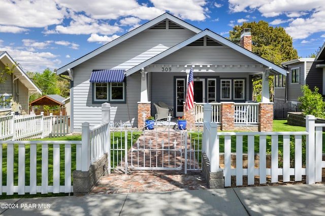 bungalow-style home with covered porch and a front lawn