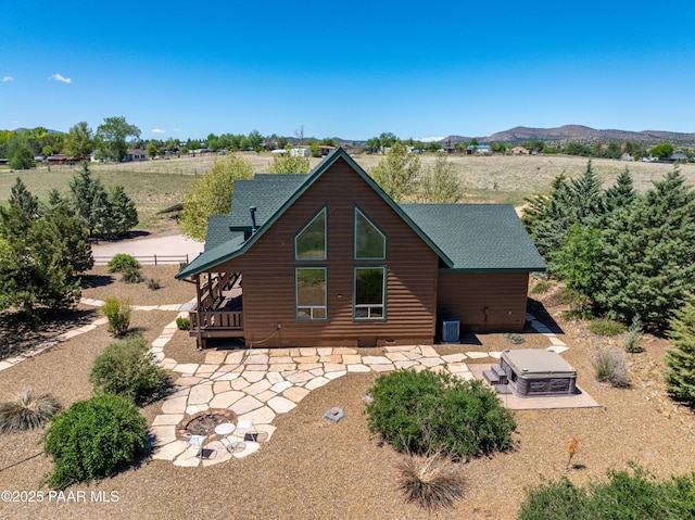 1740 W Bumblebee Rd, Chino Valley, AZ 86323 - rear view of property with faux log siding, a mountain view, a patio, and an outdoor fire pit