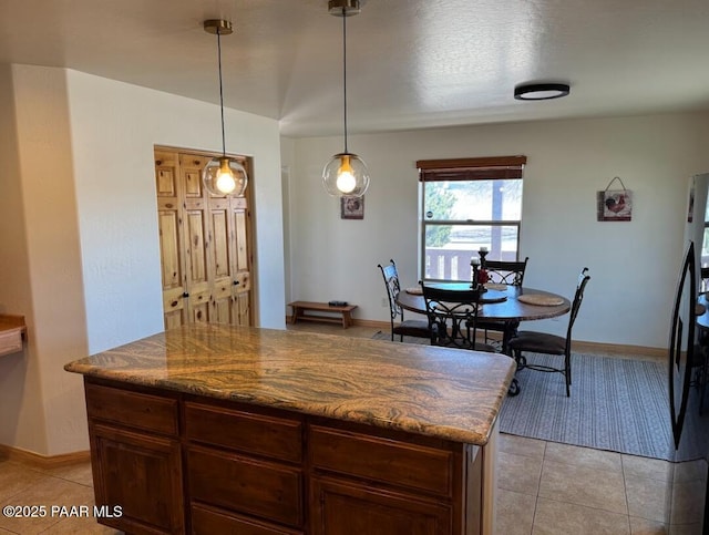 1740 W Bumblebee Rd, Chino Valley, AZ 86323 - kitchen featuring light tile patterned flooring, baseboards, freestanding refrigerator, and hanging light fixtures