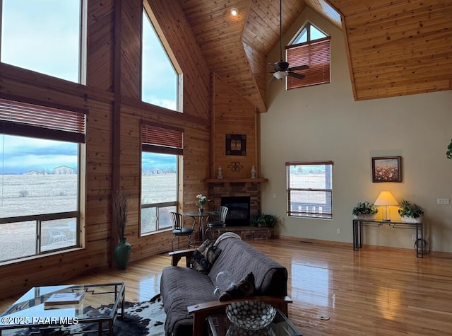 living room featuring a fireplace, wood finished floors, wood ceiling, a ceiling fan, and vaulted ceiling