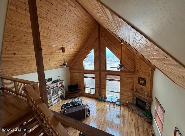 1740 W Bumblebee Rd, Chino Valley, AZ 86323 - living room with a ceiling fan, wood walls, a glass covered fireplace, wood-type flooring, and high vaulted ceiling