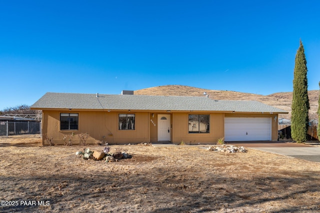 ranch-style home featuring a garage and a mountain view