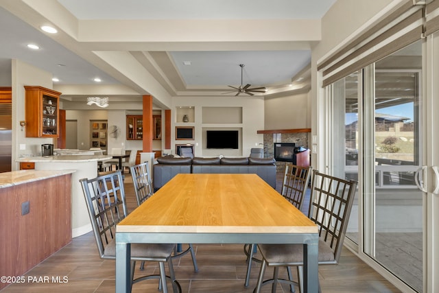 dining room with a fireplace and ceiling fan