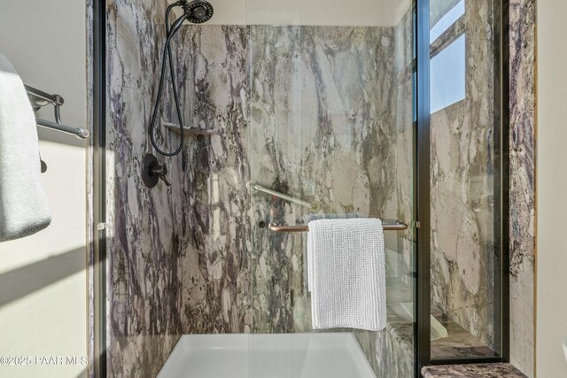 bathroom featuring a shower with shower door