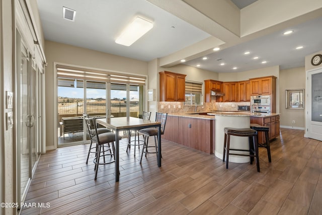 kitchen featuring kitchen peninsula, a kitchen breakfast bar, and decorative backsplash